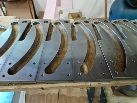 Batch of curved machined blades